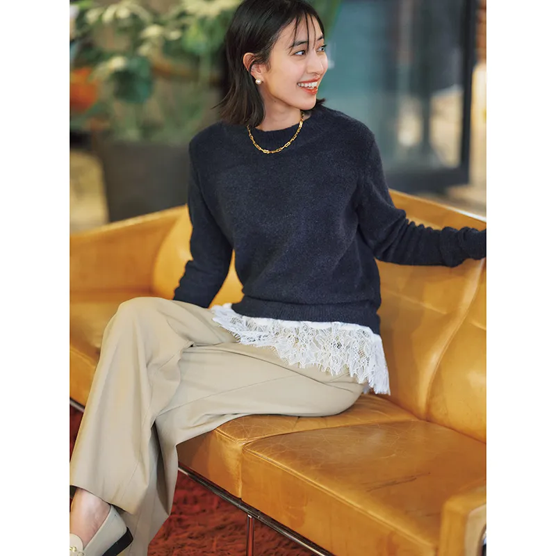 レース付きニットにゴールドのネックレス、ベージュパンツのコーデ