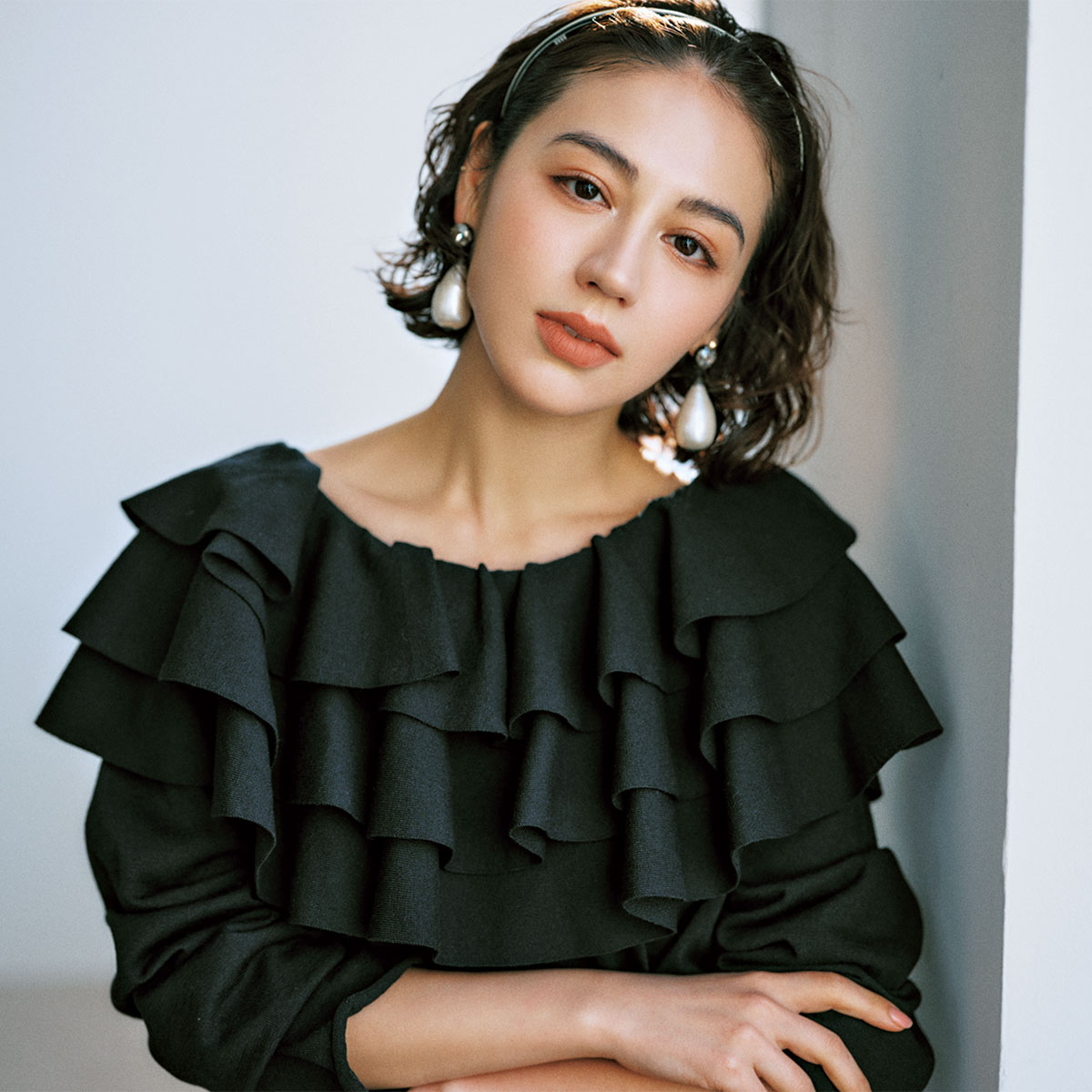 ラッフルデザインの黒ブラウス