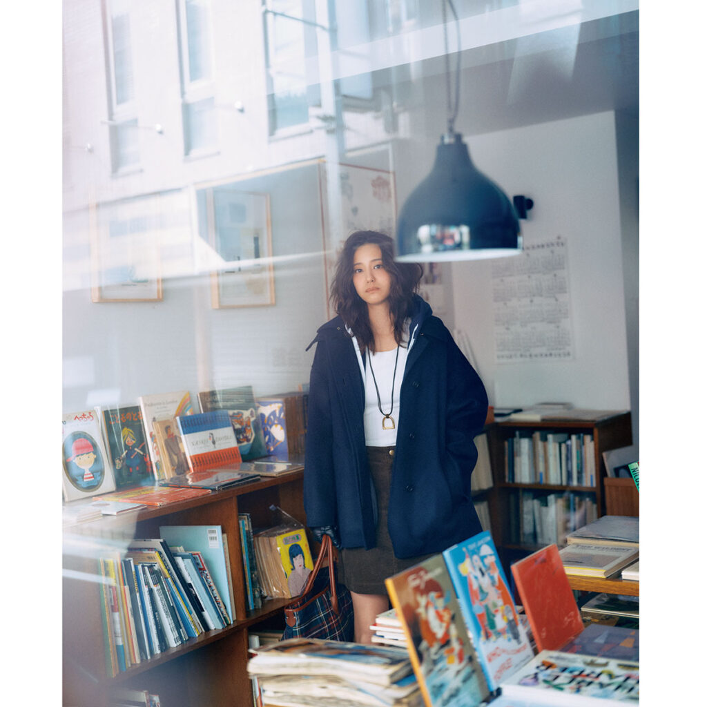 白タンクにジップアップフーディーとカーキのミニスカートのコーデ