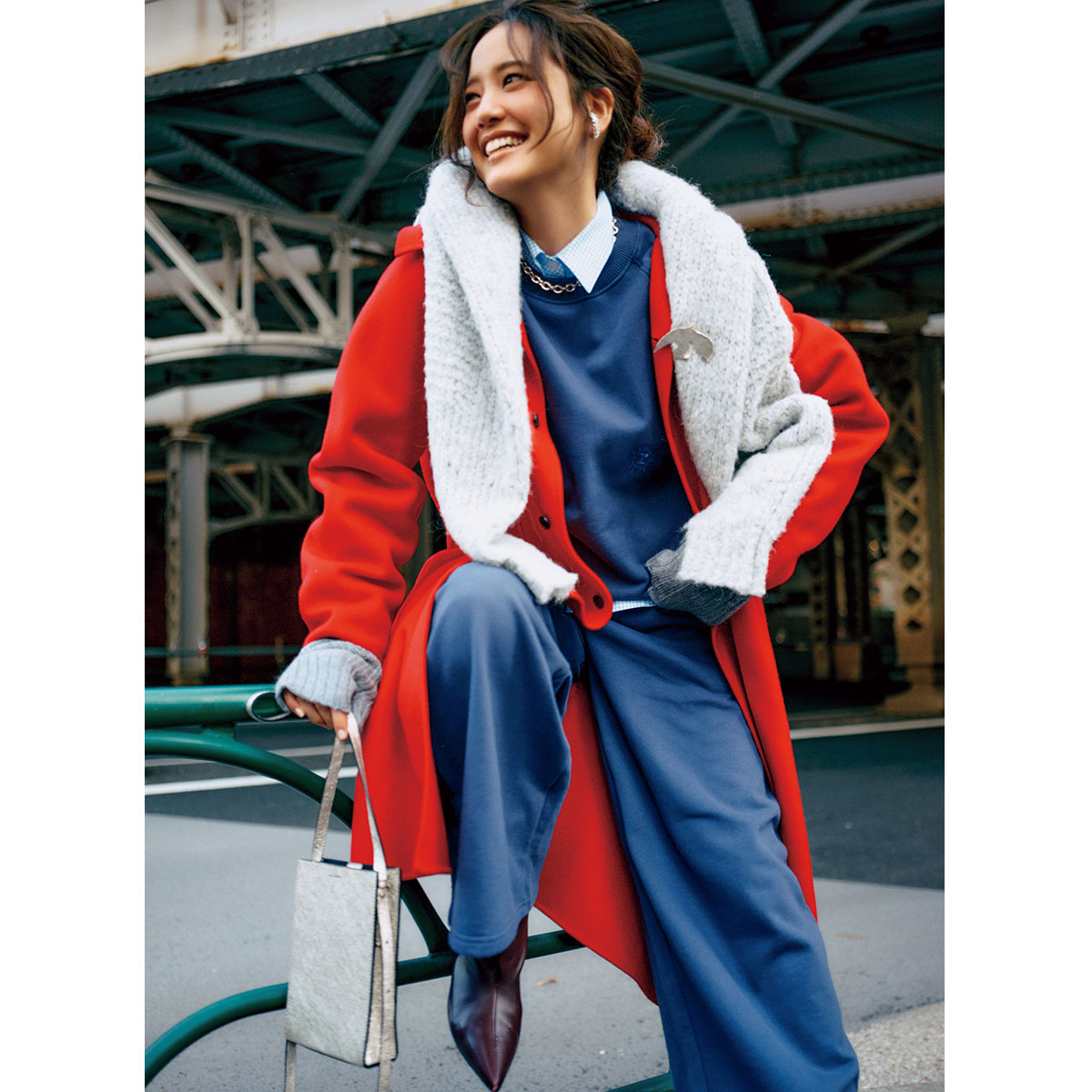 ネイビーのスウェットセットアップに赤のロングコートとブーツのコーデ