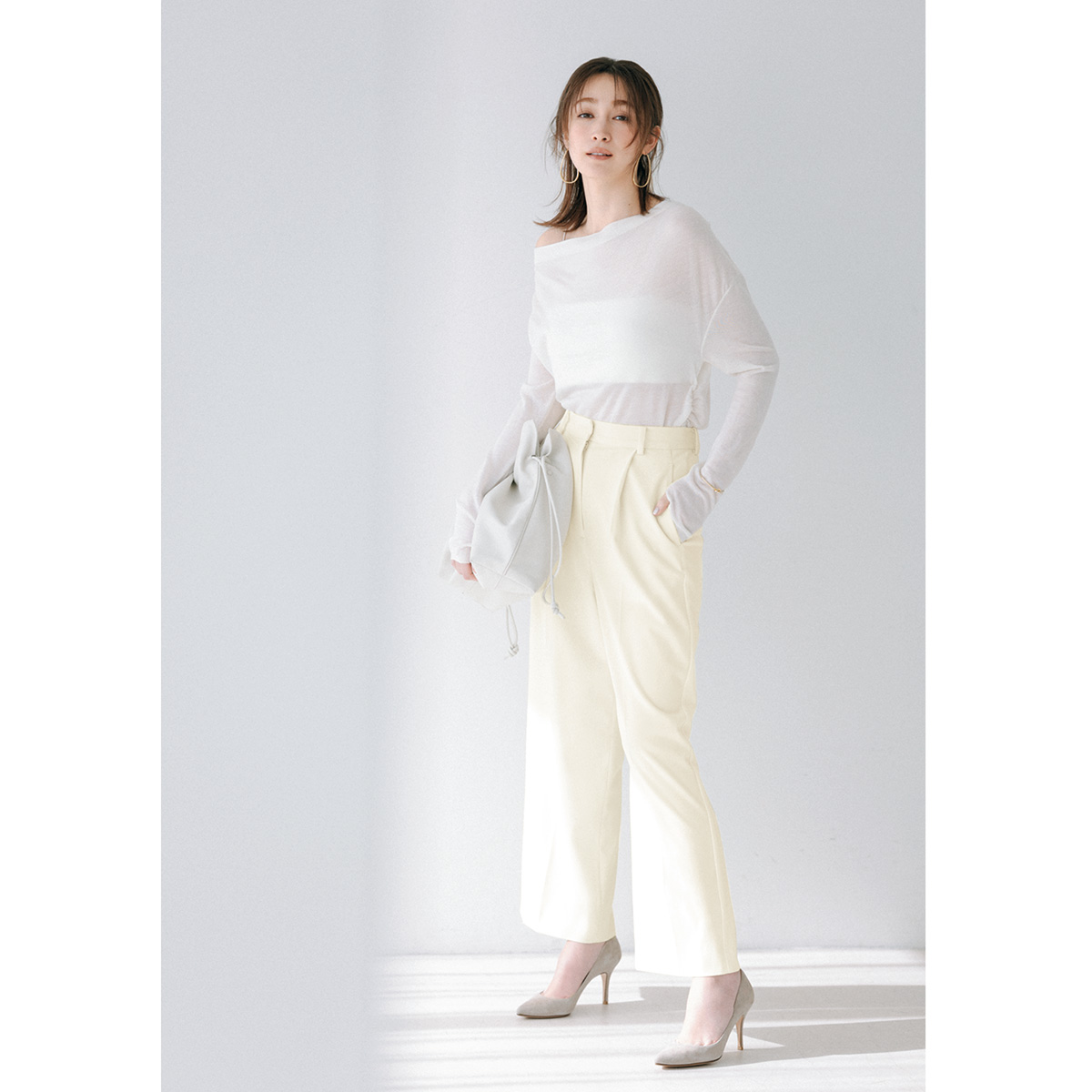 白のシアーニットにペールイエローのパンツのコーデ