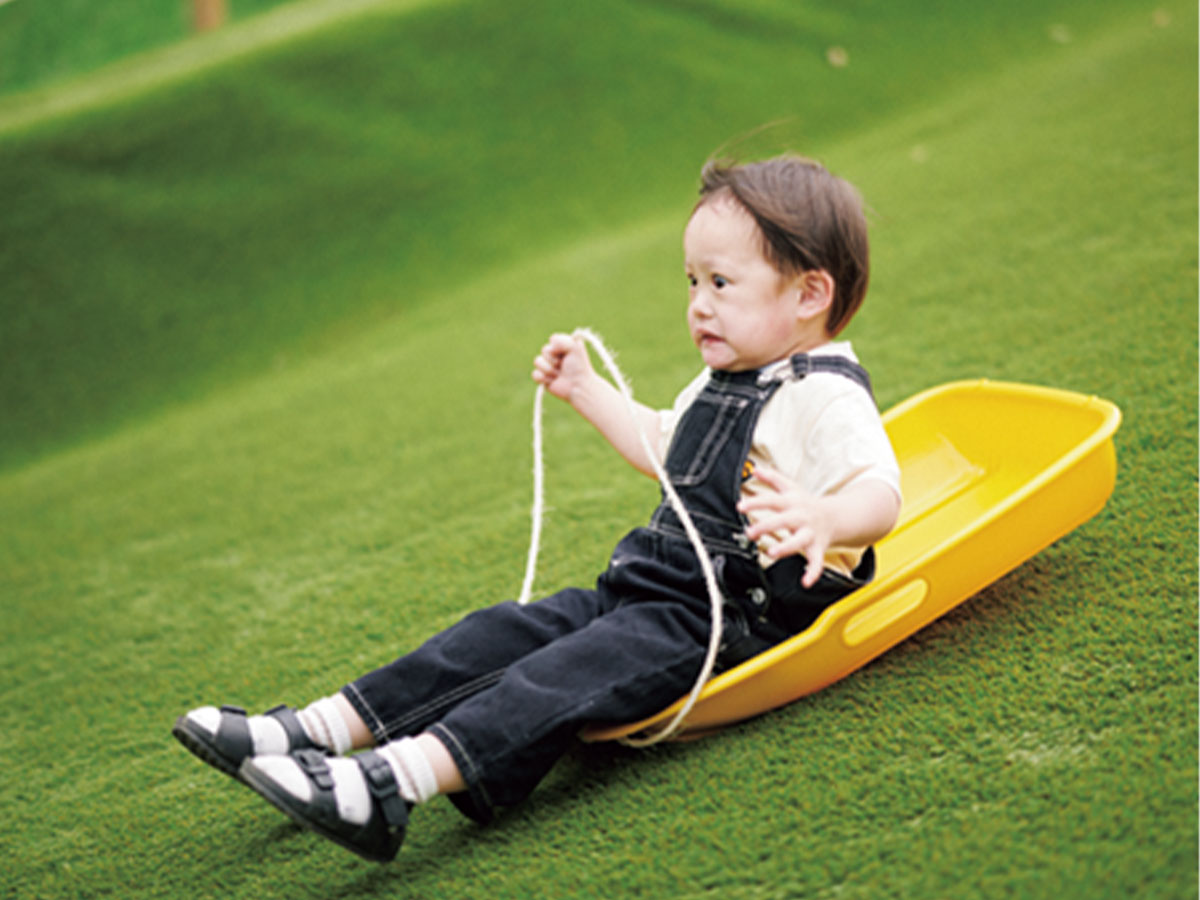 斜面をソリすべりする子ども