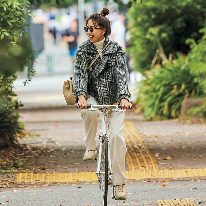 ピーコート×白パンツで自転車に乗っている東原亜希さん