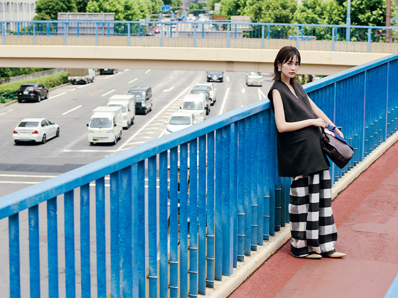 １枚で着るジレとブロックチェック柄のパンツにレザーのバッグを持った桐谷美玲さん