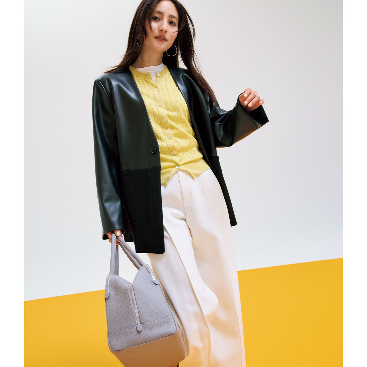 イエローカーデにレザーのノーカラージャケットのコーデ