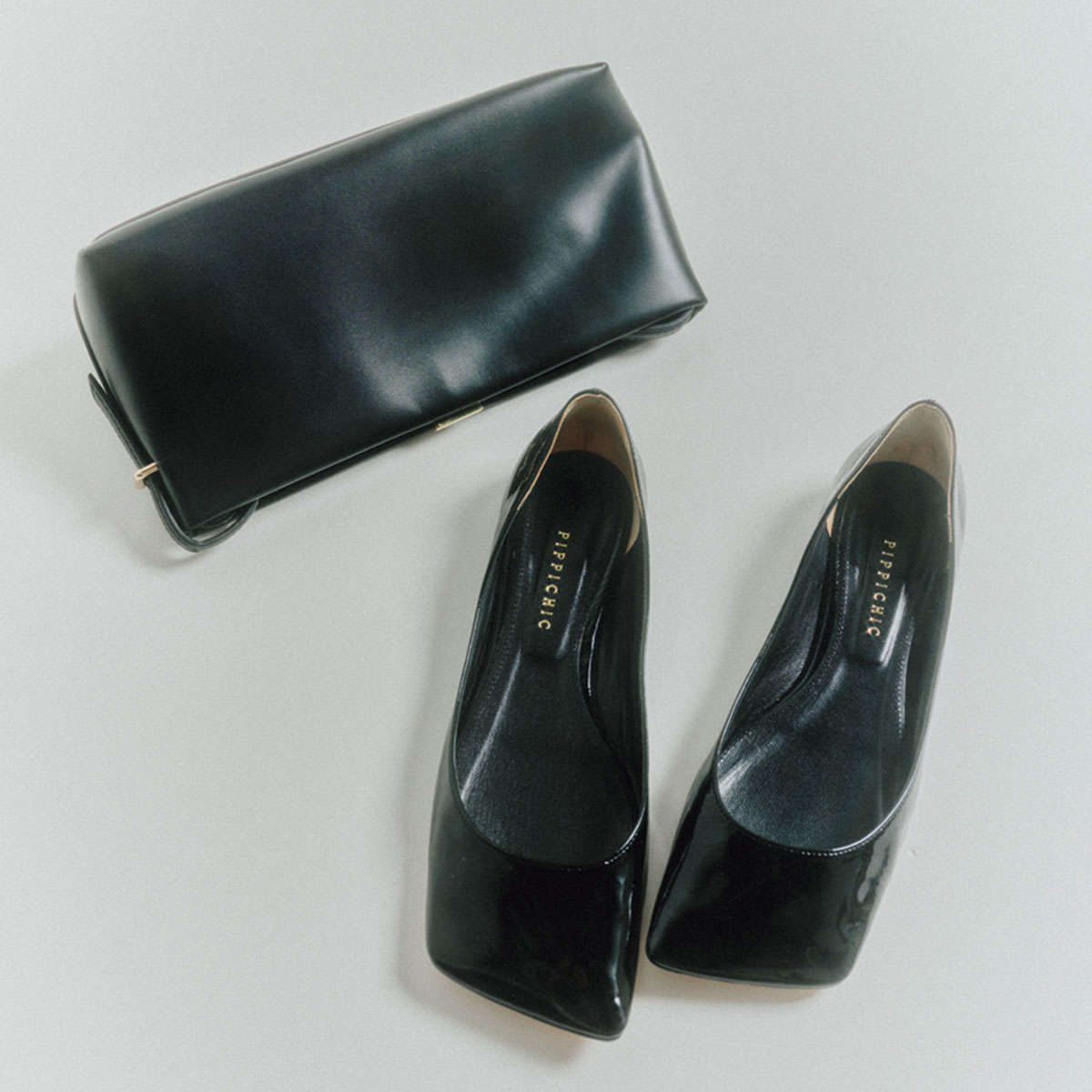黒のクラッチバッグとスクエアパンプス