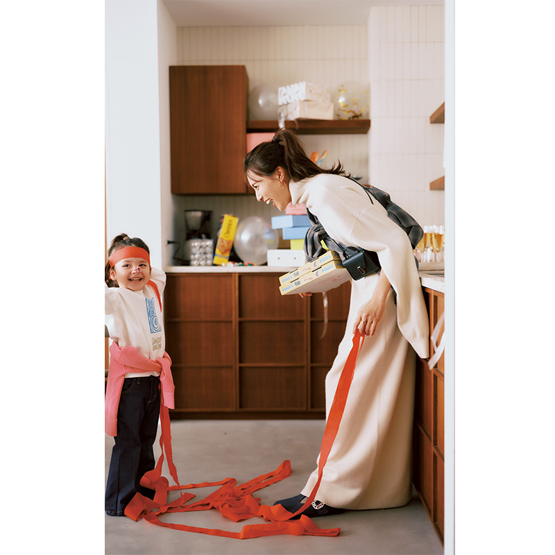 イロットのケープシルエットのニットワンピにチェックシャツやミニバッグを斜めがけしたホムパコーデ