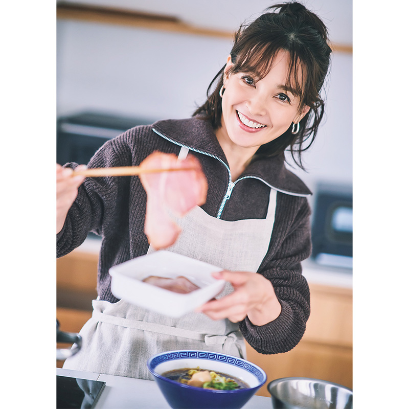 ラーメン鉢を前にチャーシューをお箸で持ち上げて微笑む女優の国仲涼子さん