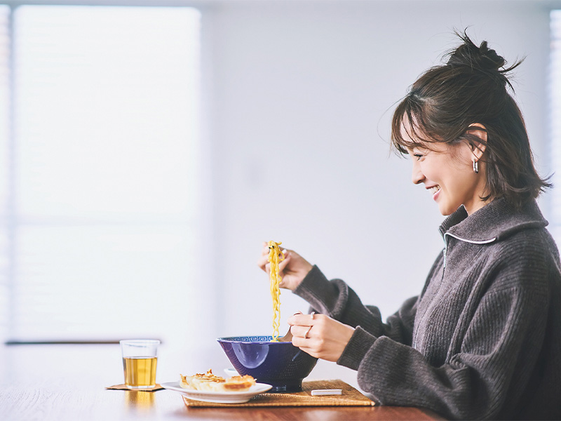 嬉しそうにラーメンの麺を箸で持ち上げる女優の国仲涼子さん