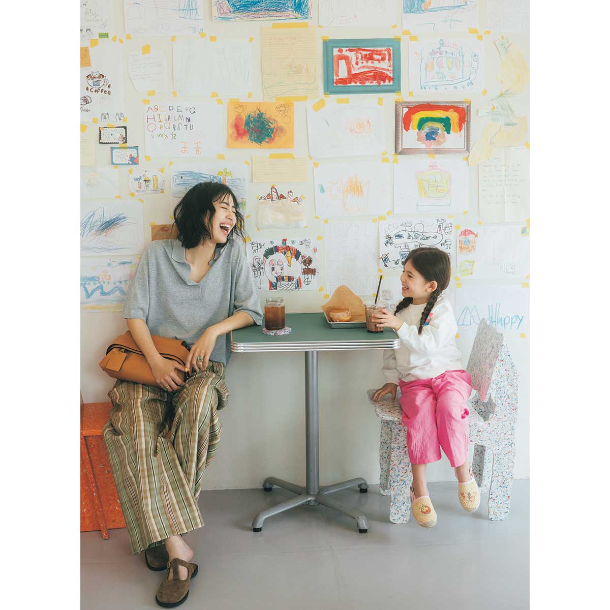 グレーのスキッパーポロニットとチェック柄パンツを着たママと女の子