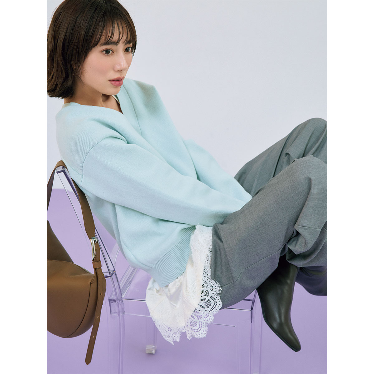 レースノースリーブ付きレイヤードニットにグレーパンツのコーデ