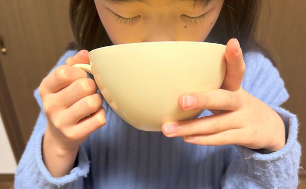 カインズ「グラノーラ・スープ用カップ HAJIKU ベージュ」でスープを飲む図