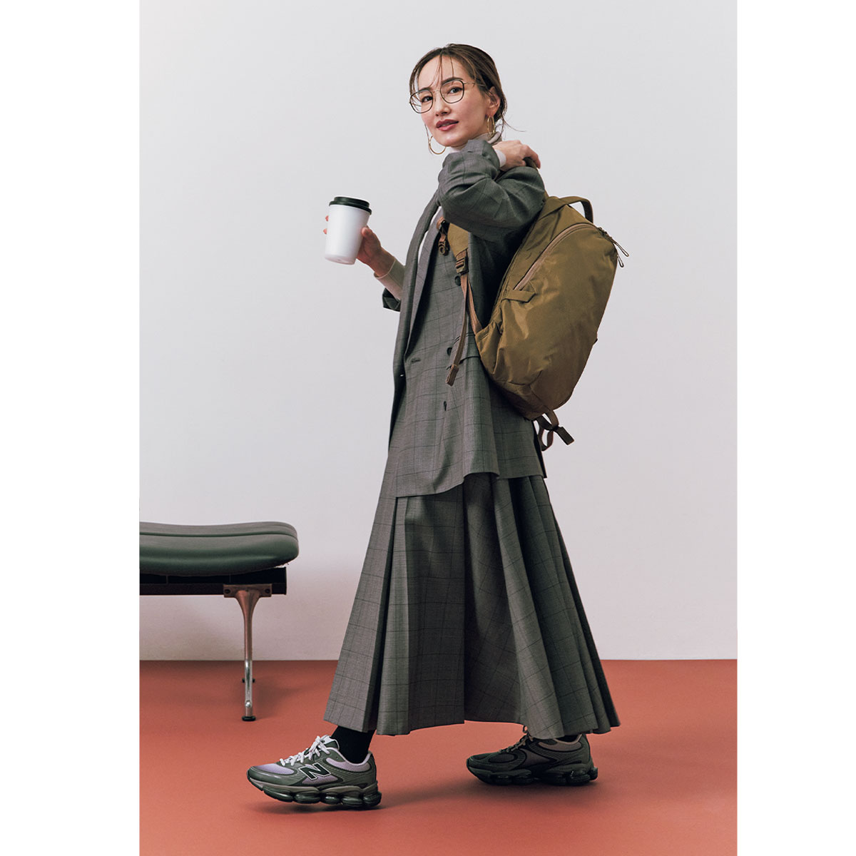 チェック柄ジャケットとスカートのセットアップにニューバランスのスニーカーとエイブルキャリーのリュックを背負ったコーデ
