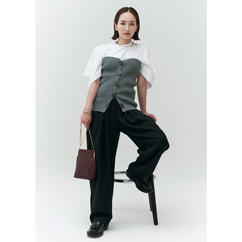 ヘリンドットサイの白Tシャツにニットビスチェを重ねてパンツを合わせた着こなし