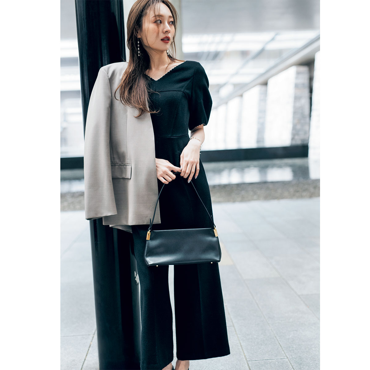 黒のオールインワンにジャケットの肩掛けコーデ