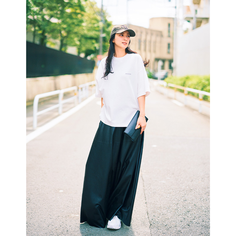 ゆるっとした白Tシャツとロングスカートをカーキ色のキャップや白スニーカーで着こなす武井咲さん