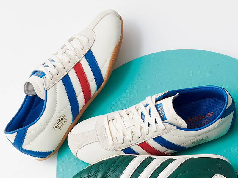 adidas Originalsの赤と青のライン入り白スニーカー