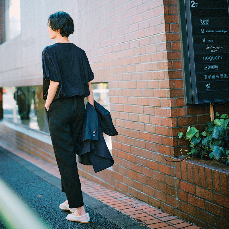 袖口と裾がバルーンデザインになった黒Tシャツとタイトな黒パンツを合わせたきちんとコーデ