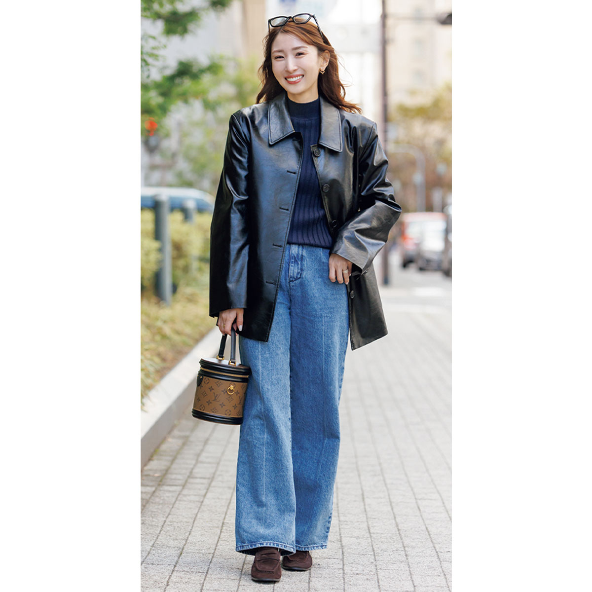 ネイビーニットに長め丈のレザージャケットとデニムパンツのコーデ