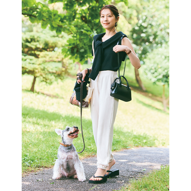 ローブブランのトップスにH&Mの白スウェットパンツを穿いて犬の散歩をする楫真梨子さん
