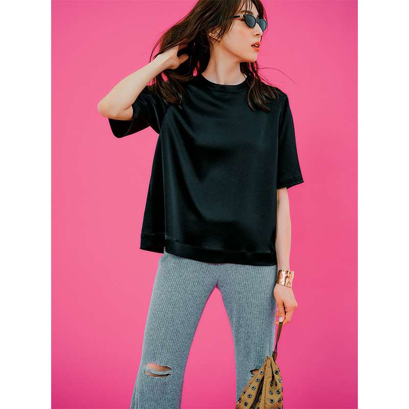 黒のサテン生地五分袖Tシャツに細身のパンツ
