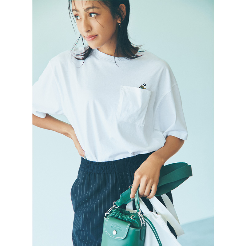 Tシャツとストライプ柄のパンツにグリーンのバッグを持った運動会コーデ