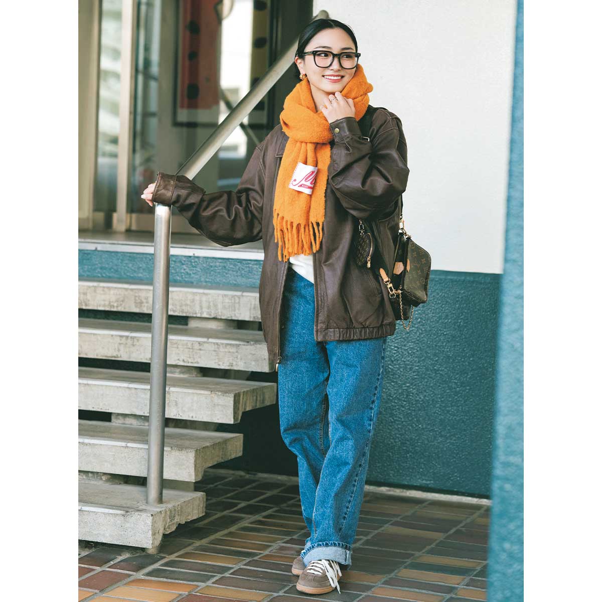 オーバーサイズブルゾンとデニムパンツにオレンジマフラーのコーデ