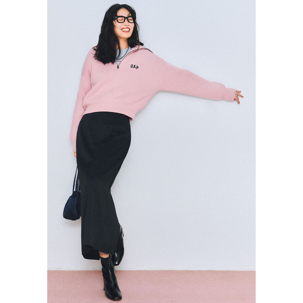 ピンクのハーフジップスウェットに黒スカートのコーデ