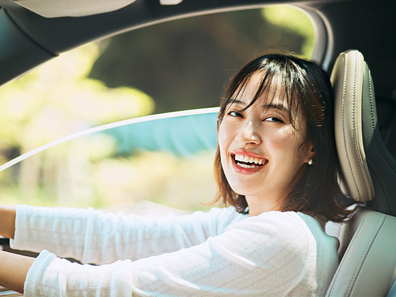 車の運転席で微笑む岡本あずささん