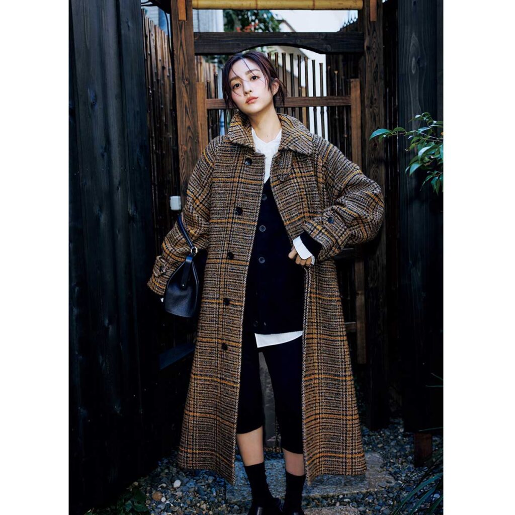 黒カーデと白シャツのレイヤードにハンパ丈パンツとチェック柄コートのコーデ