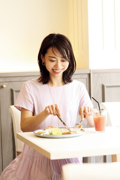 クレープスノカオイ成城店の店内でクレープを食べている女性の写真