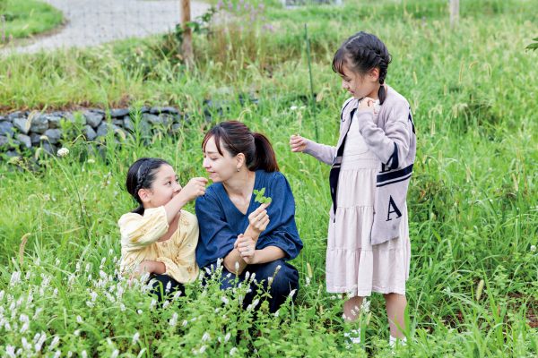 摘んだハーブの香りをかぐ親子