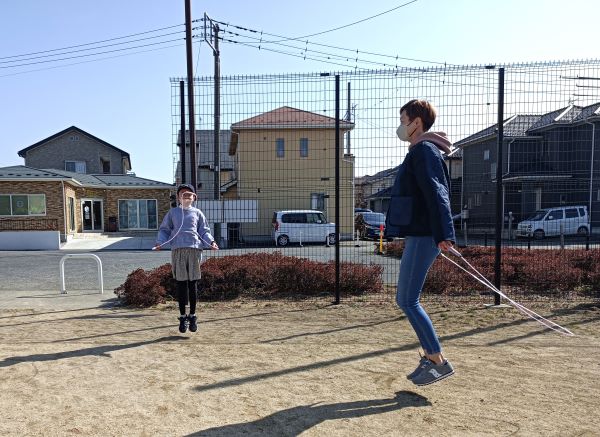 公園で子どもと縄跳びをする図