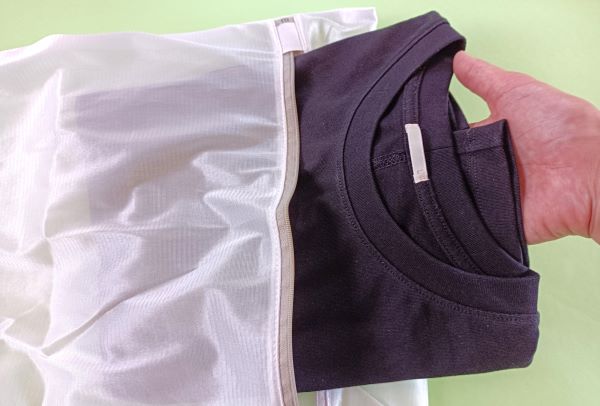 セリア「シルク風洗濯ネット」に黒いTシャツを入れる図