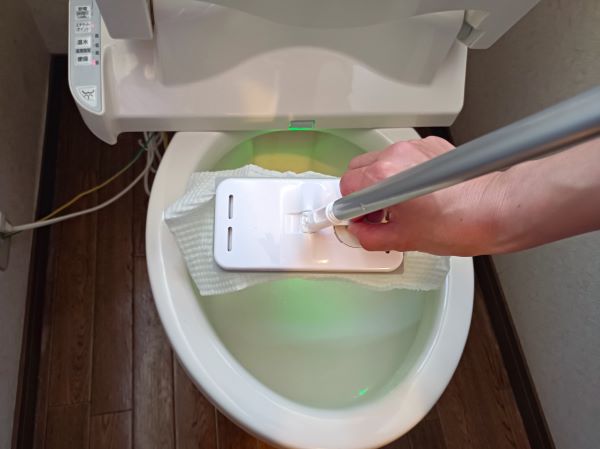 カインズ「トイレ用床ワイパー」に挟んだシートを便器に捨てる図