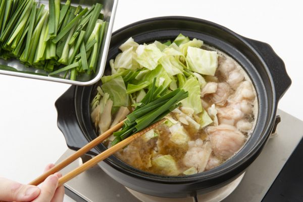 もつ鍋に野菜を入れる