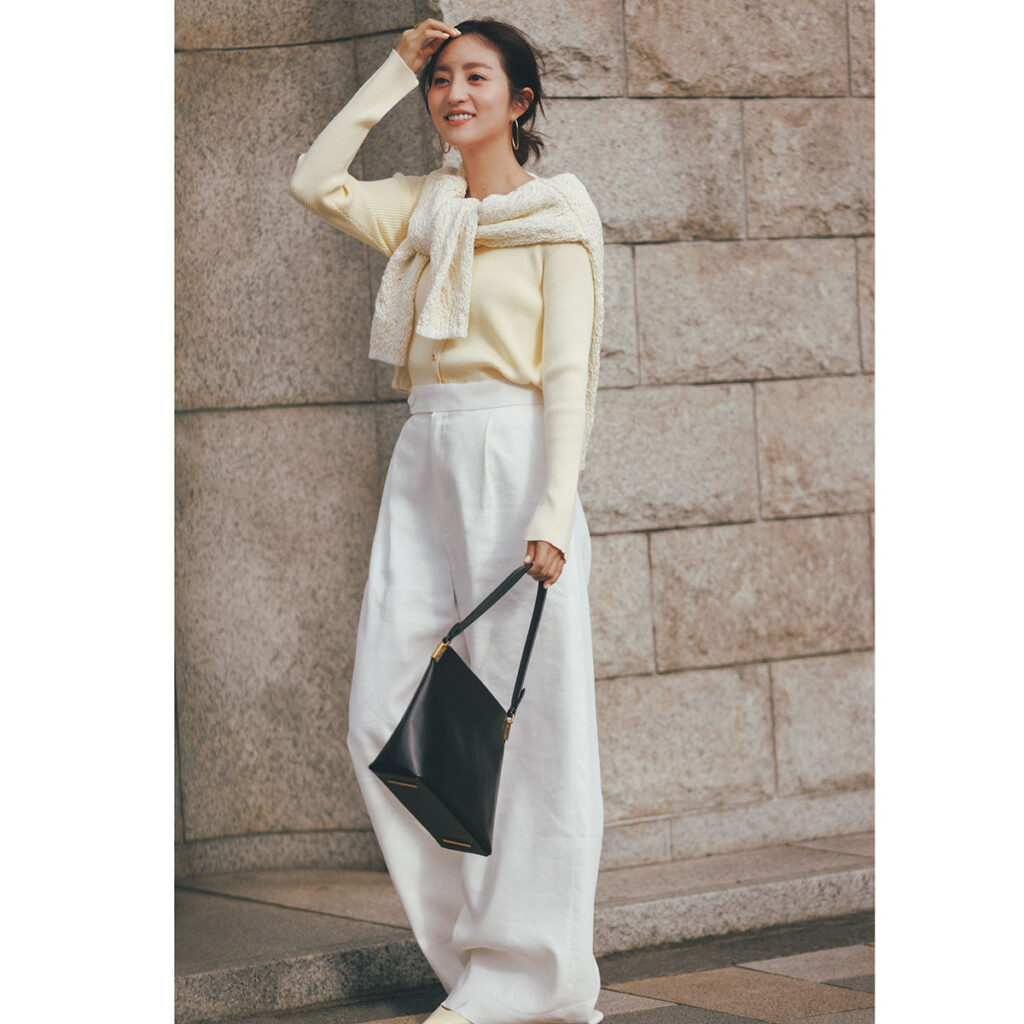ペールイエローのカーディガンに白のワイドスラックスのコーデ