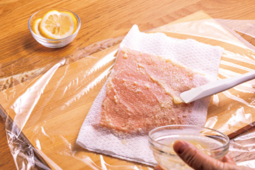 サーモンをペーパータオルで包み、その上から塩麹を塗る